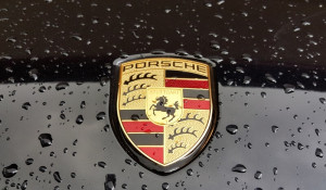 Porsche logo on black car with rain drop